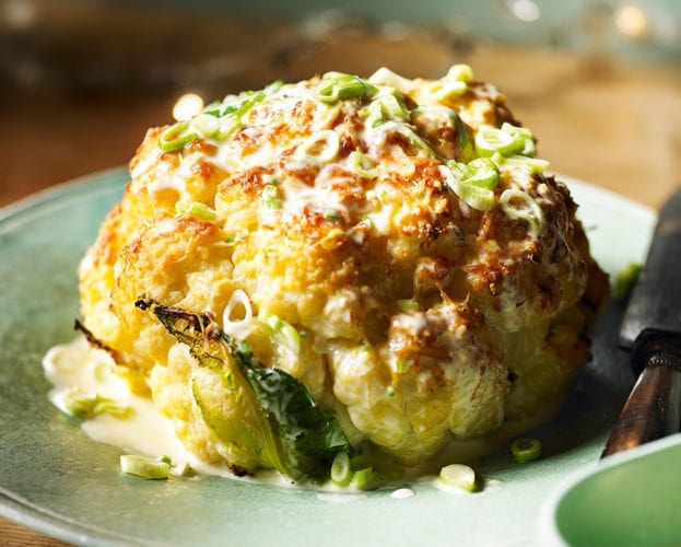 Whole roasted cauliflower with cheddar and spring onion sauce