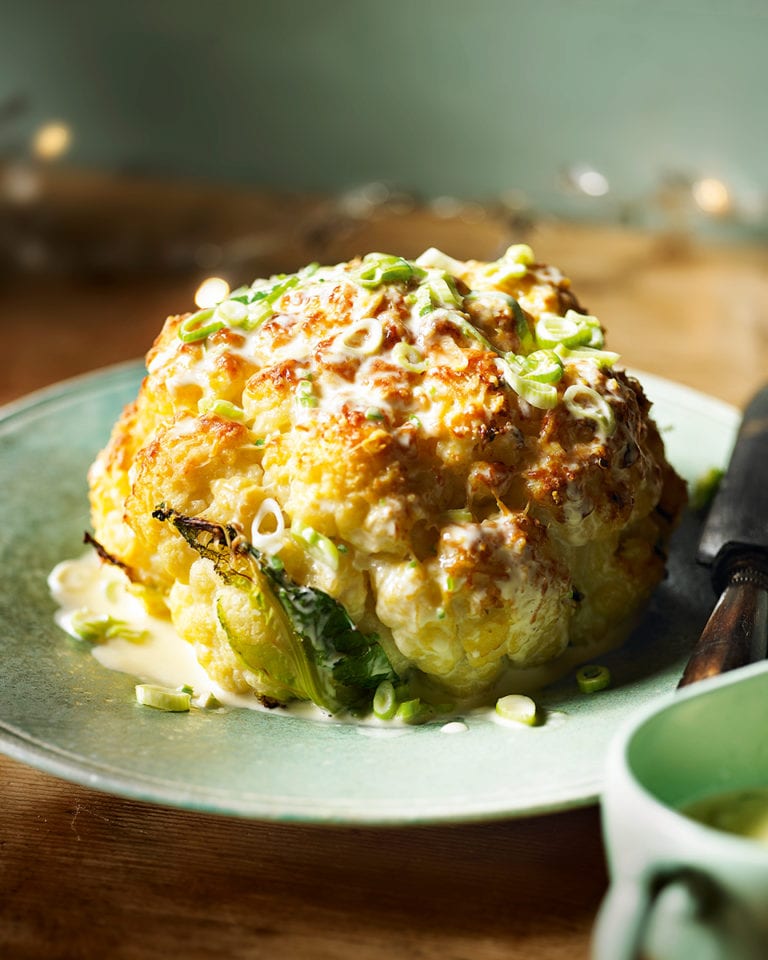 Whole roasted cauliflower with cheddar and spring onion sauce
