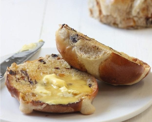 image of hot cross bun sliced in half and buttered