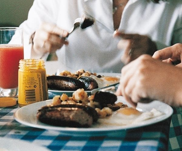 People eating potato hash around a table