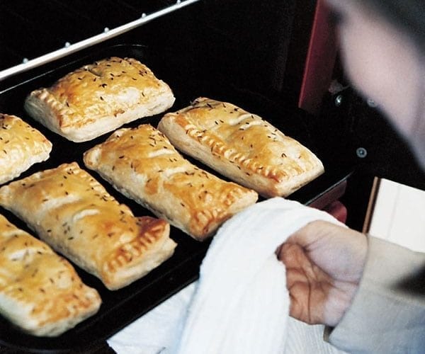 Sausage pies coming out of an oven