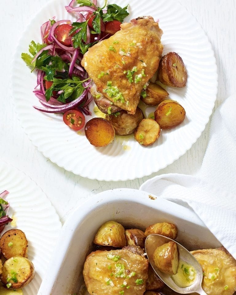 Roast chicken thighs with garlic butter potatoes and tomato salad