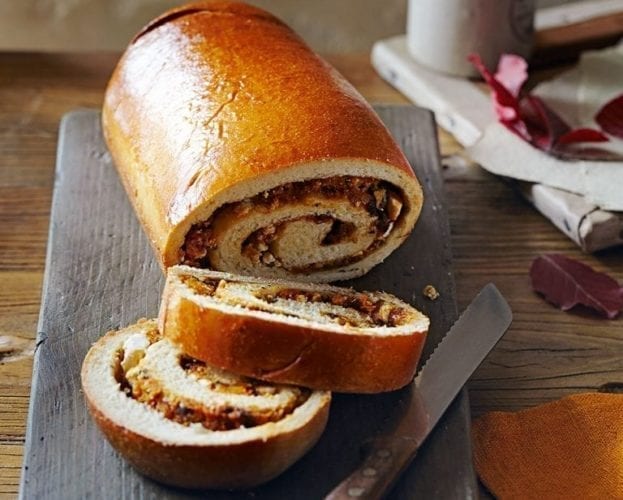 A rolled up loaf, with a circular swirl of colourful butternut squash inside