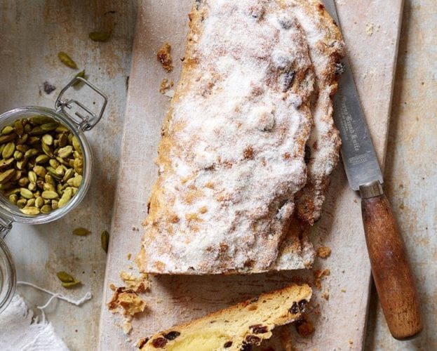 Christmas stollen shown on a wooden board, with slices taken out