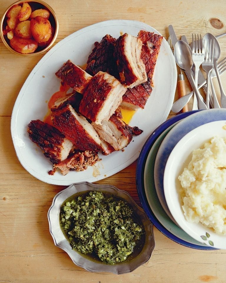 Five-hour roast pork belly with roast potatoes and salsa verde