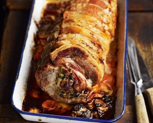 Roast loin of pork show cooked in a white enamel baking tray