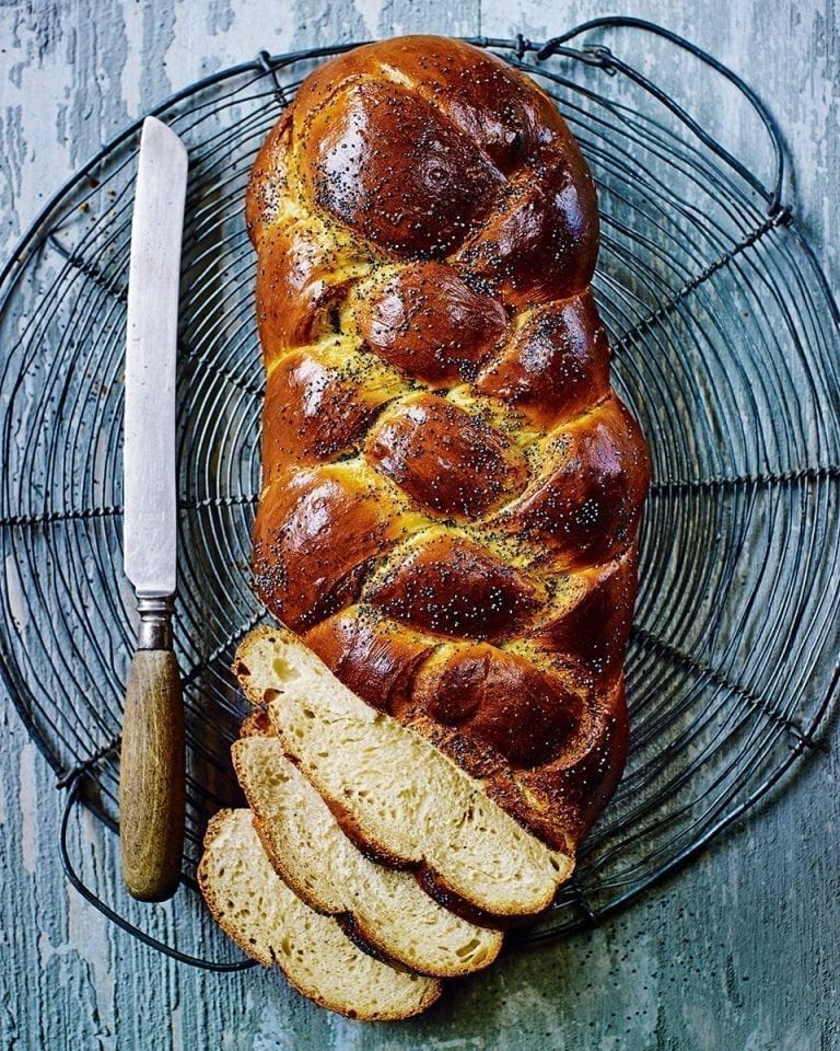 A plaited challah loaf of bread, shown with slices