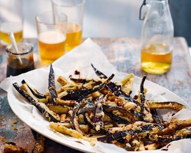 Aubergine fries shown on a plate with greaseproof paper