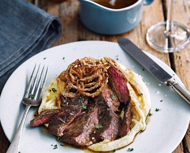 Cooked onglet steak shown sliced and sitting on mash