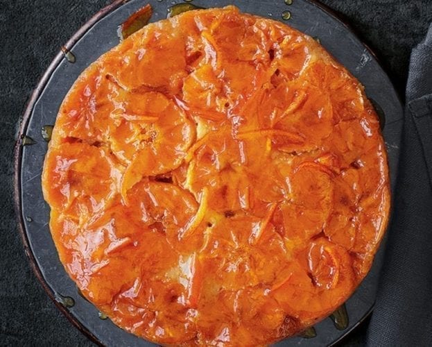 Clementine upside down cake, turned out, on a dark backgroun