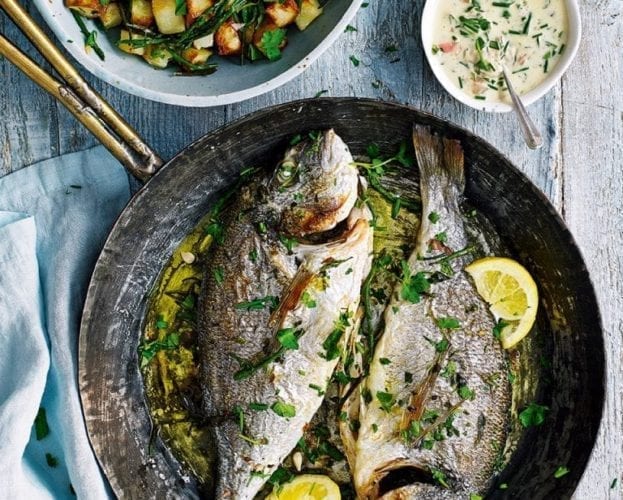 Two roasted sea bream fish, shown in a fry pan