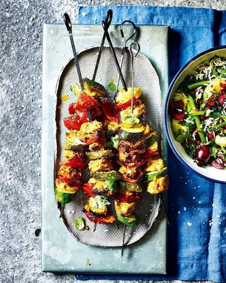 Tandoori-style chicken skewers with green rice and cherry salad