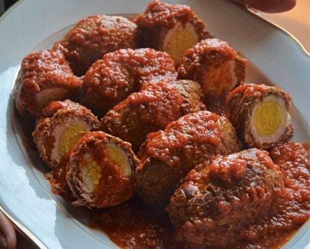 Beef rolls, or falsomagro, shown on a plate, with one cut into to reveal the hard-boiled egg
