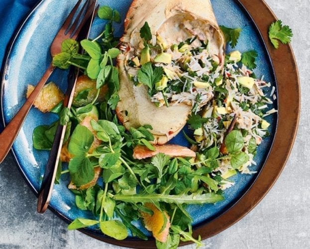 Whole dressed crab with Thai chilli sauce, shown on a blue plate