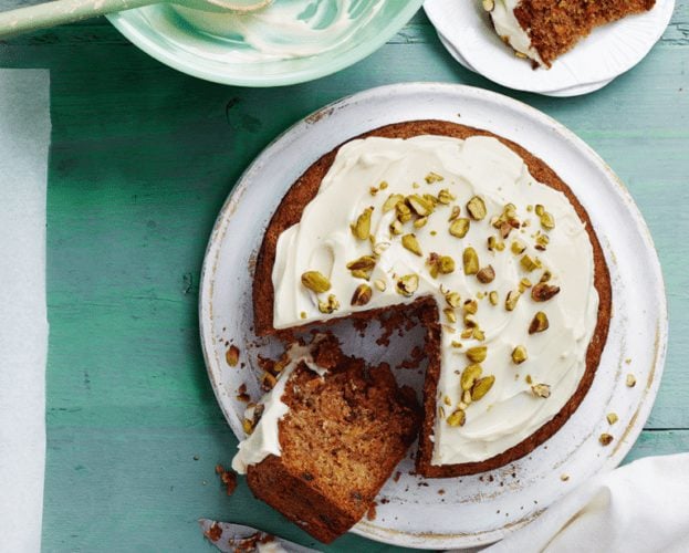 A classic carrot cake shown from above on a plate, with a slice cut out