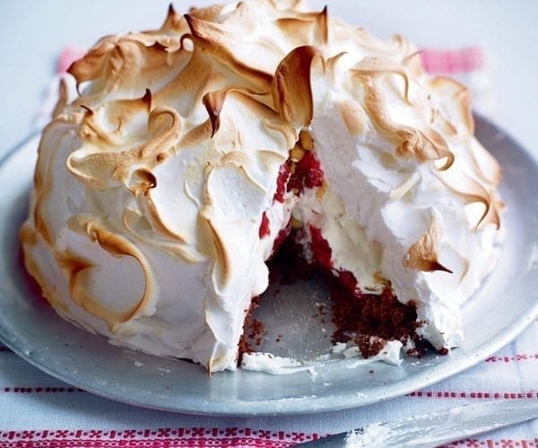 Baked Alaska with a slice taken out, shown on a plate