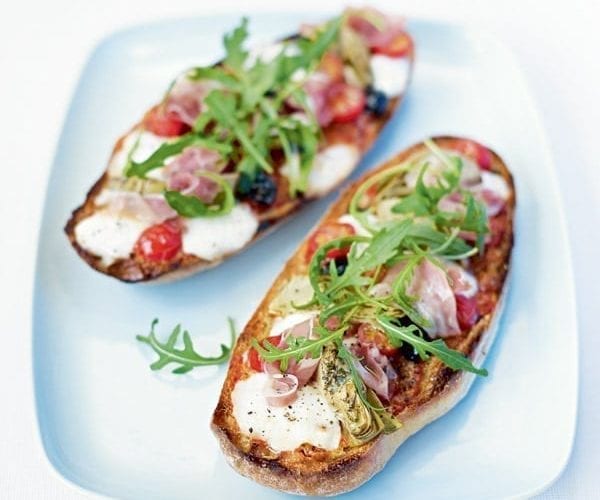 Two pizzas on a plate, made with ciabatta bases