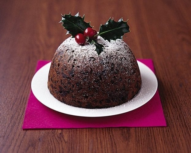 Traditional Christmas pudding with a holly and berry decoration on top