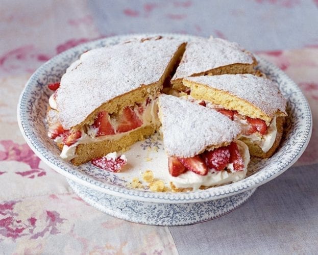Strawberry shortcake cut into wedges, on a plate