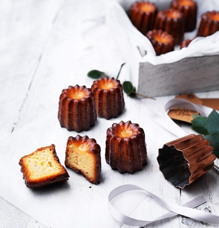 Caneles shown on a table, with one sliced in half