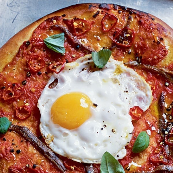 Anchovy and fried egg pizzas