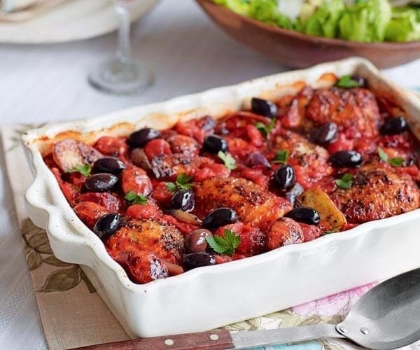 Chicken cacciatore with black olives in a white dish