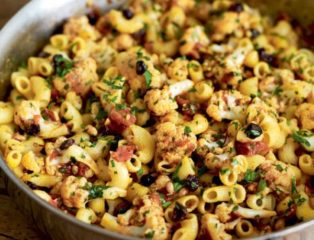 Pasta with cauliflower, currants and pine nuts in a silver pan