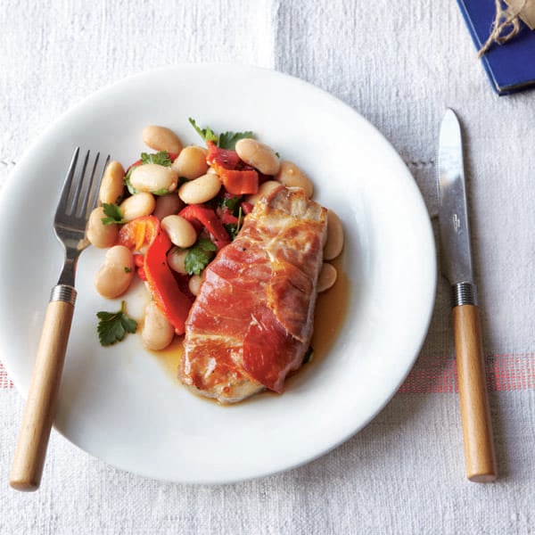 Pork steaks wrapped in Parma ham with butter bean salad