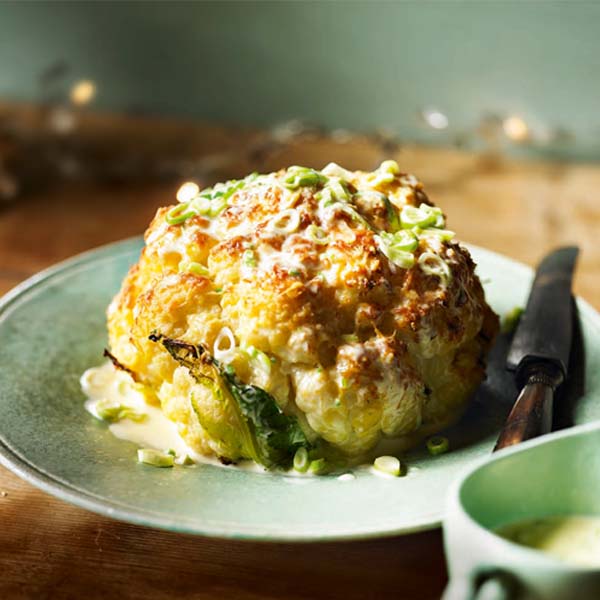 Whole roasted cauliflower with cheddar and spring onion sauce
