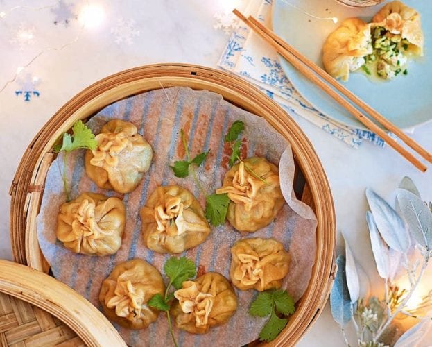 Chicken momos shown in a bamboo steamer
