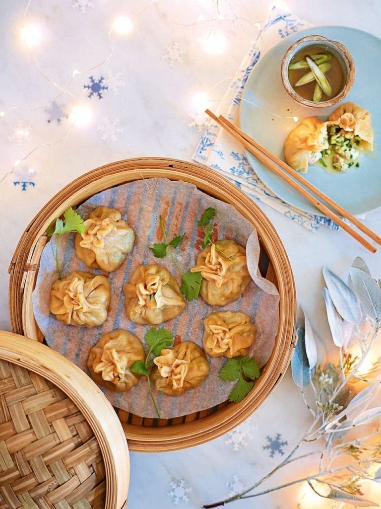 Chicken momos shown in a bamboo steamer