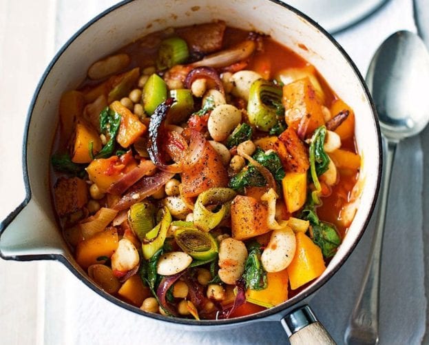 Colourful butterbean stew shown in a white pan