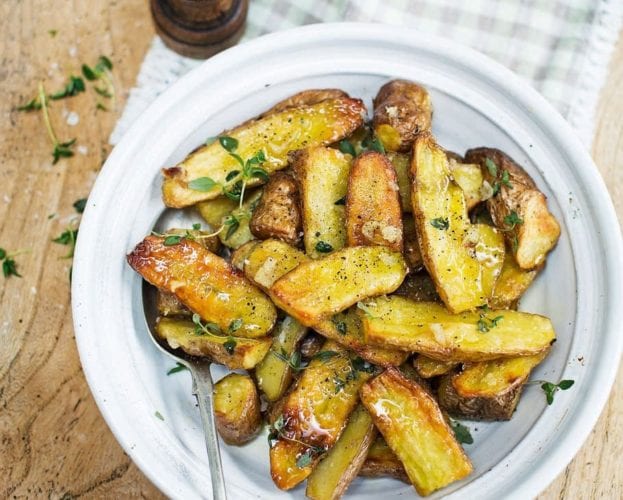 Roast pink fir apple potatoes with garlic, shown in a bowl