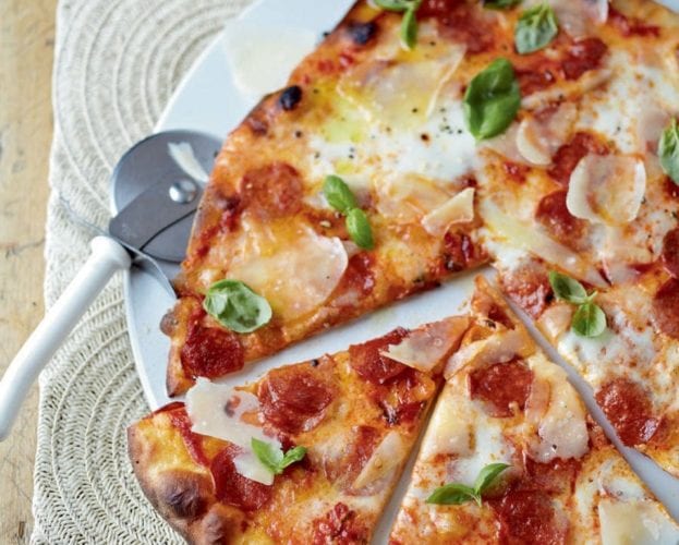 A homemade pepperoni pizza cut into slices