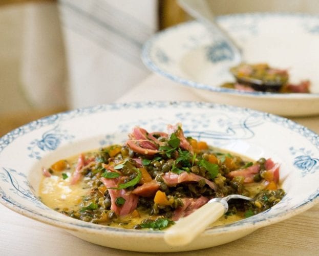 Cooked ham hock with lentils shown in a bowl