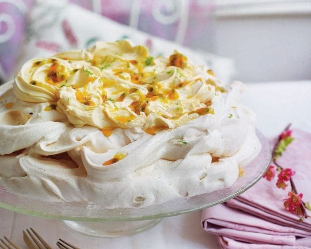 Passion fruit pavlova, shown on a glass stand