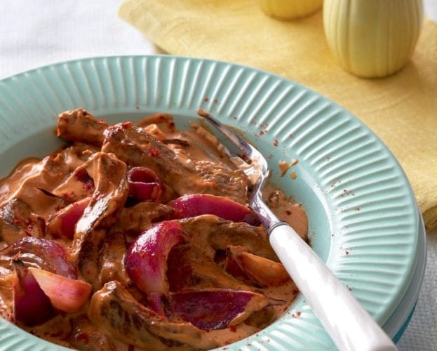 Beef stroganoff shown in a pale blue plate.