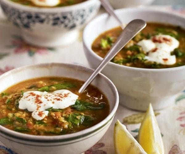Lentil soup topped with garlic yogurt, shown in a bowl