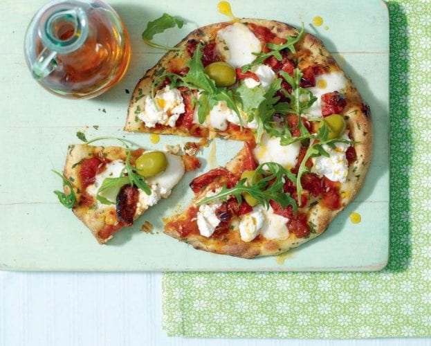 Pizza made with a naan base, shown with a slice cut out