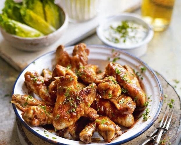 Buffalo chicken wings with celery sticks and blue cheese dip