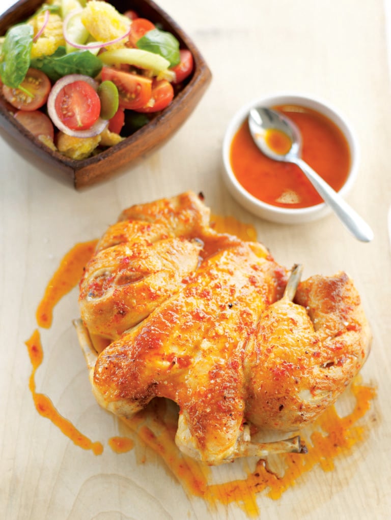 Spatchcocked roast chicken with chilli coating and tomato salad