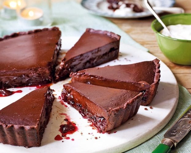 Chocolate and cherry tart, cut into slices revealing the cherry layer inside