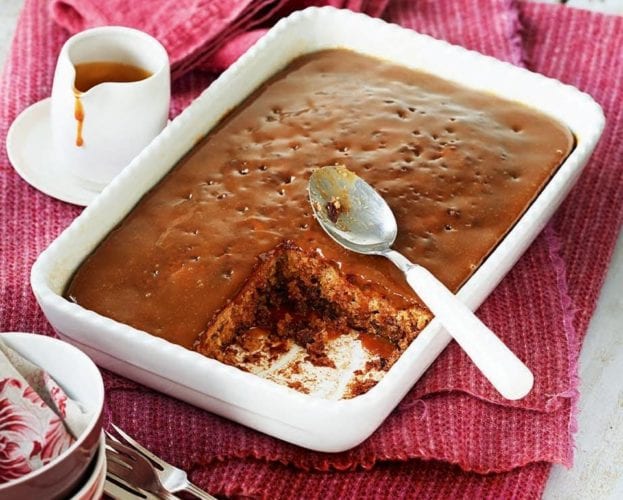 Sticky toffee pudding in a dish, with a corner cut out
