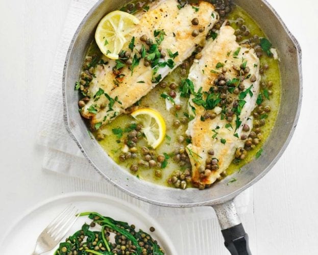 Lemon sole topped with lemon and capers, shown in a frying pan