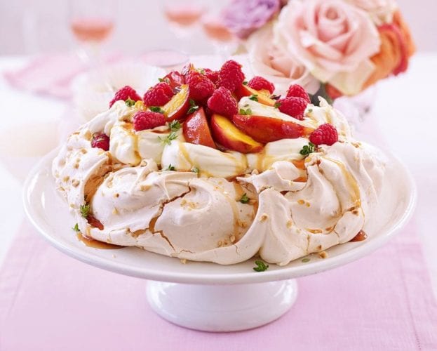 A fruit pavlova, finished, and shown off on a cake stand