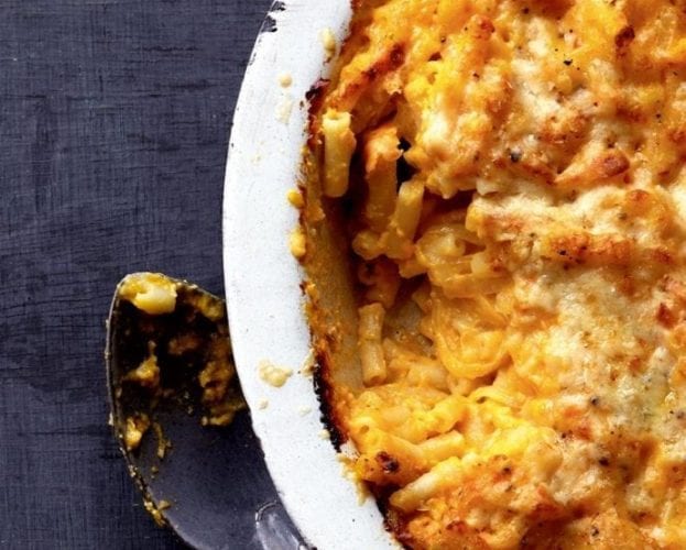 Macaroni cheese in a white bowl on a dark backgroun
