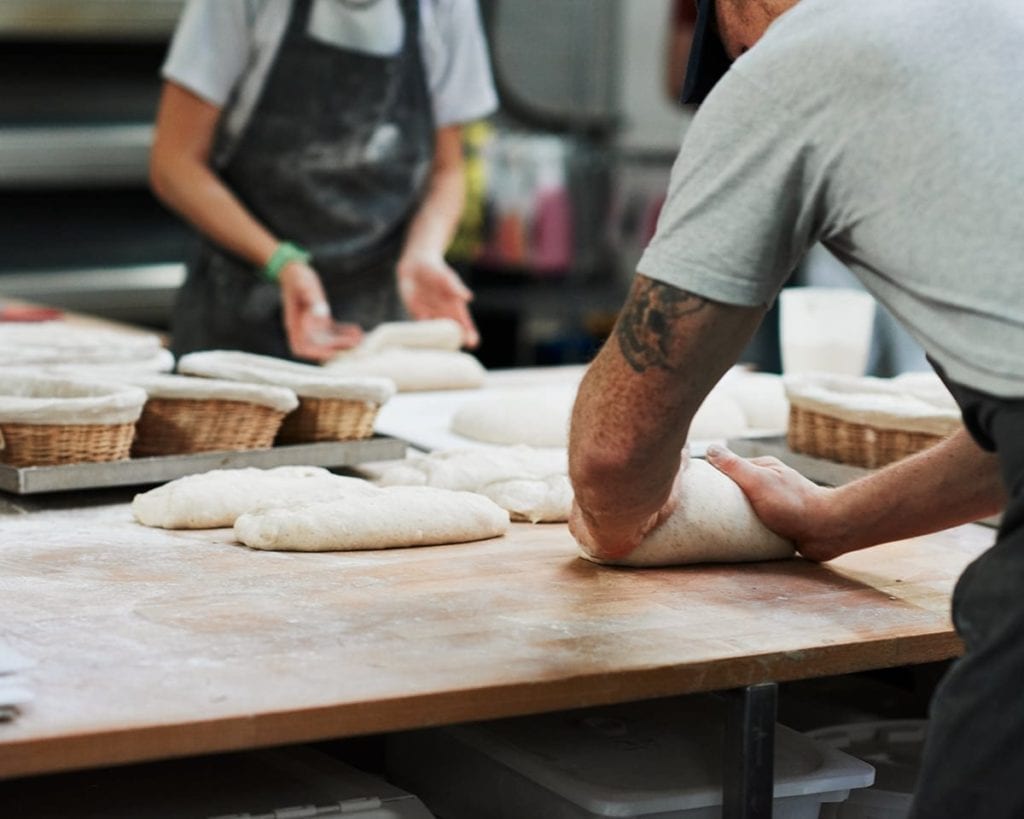 Image of two bakers kneading dough