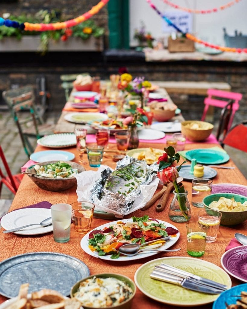 Image of large colourful tables laden with food