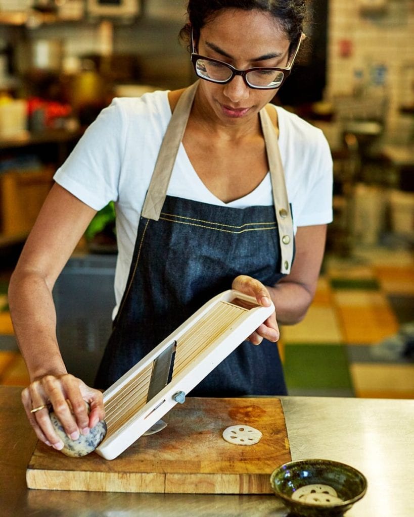Image of chef Yohini slicing lotus root 