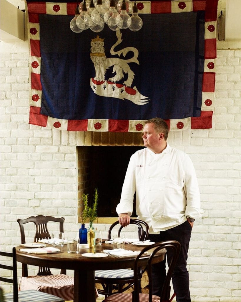 Image of chef standing at a table in the Goodwood restaurant